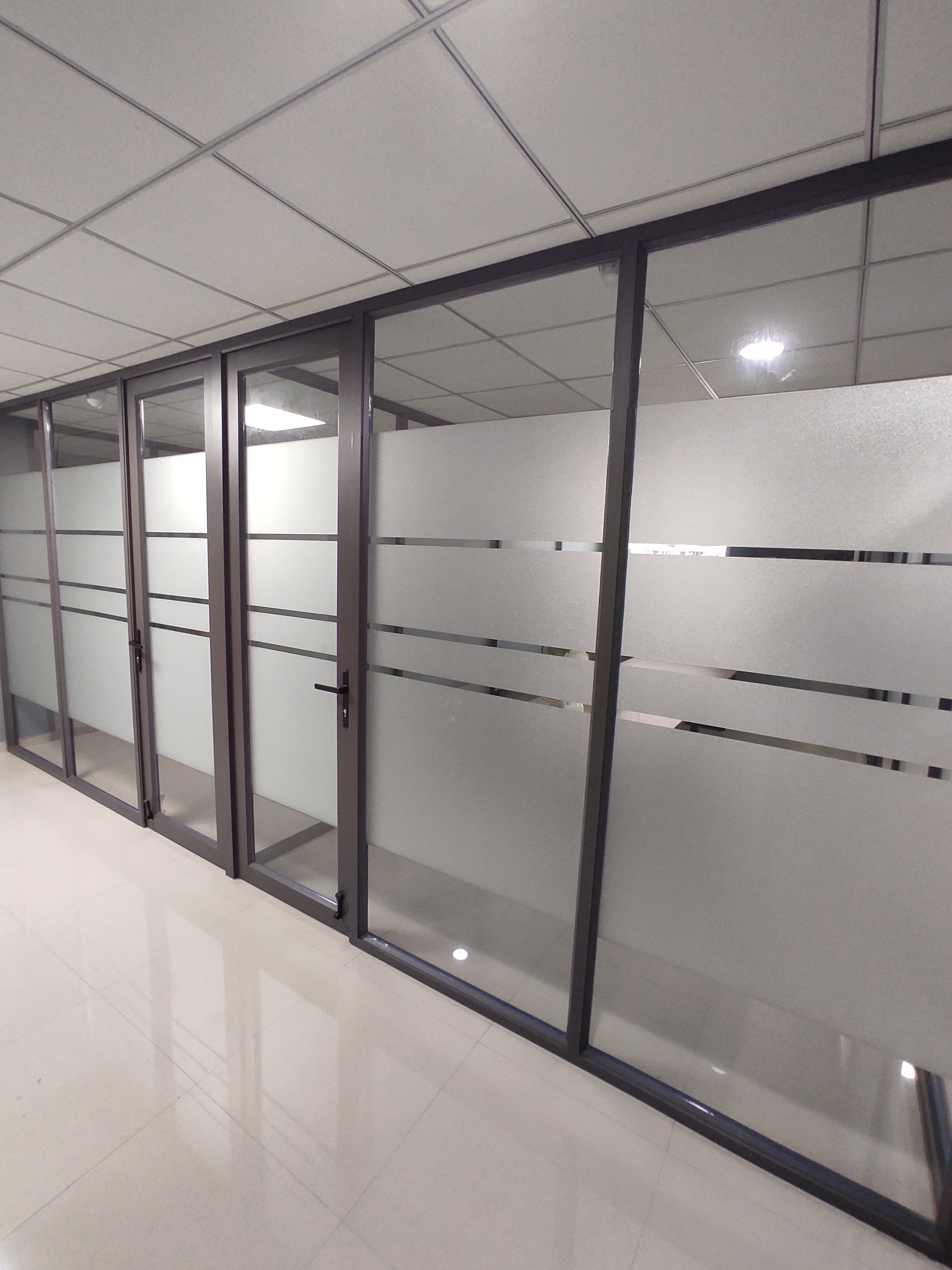 Row of cabins with glass doors along the office floor